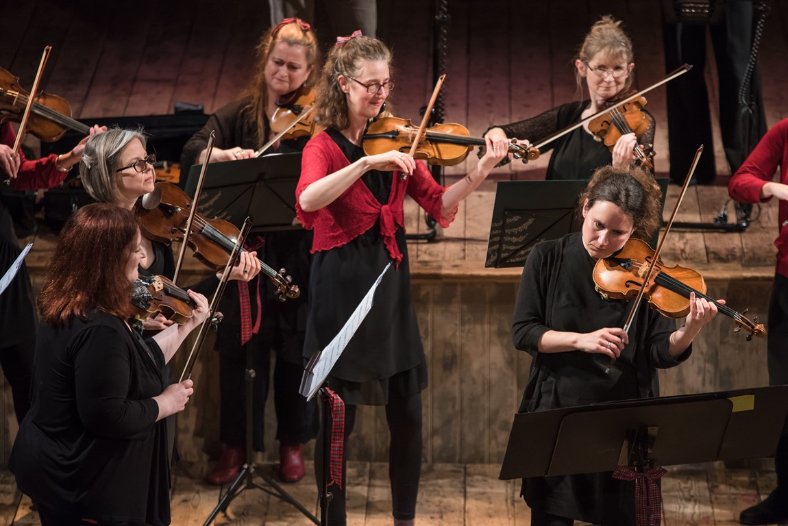 Close up of Violinist Jane Carwardine standing playing the violin in a cathedral