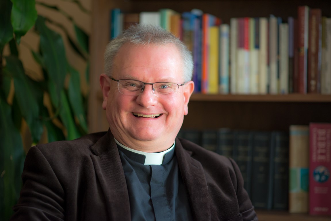 Head and shoulder close up of a smiling Roger Bush, Dean of Truro Cathedral